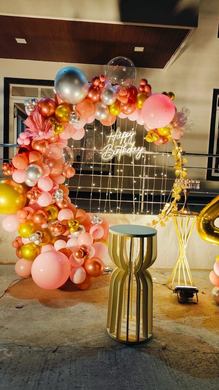 Birthday celebration with balloon arch and lights