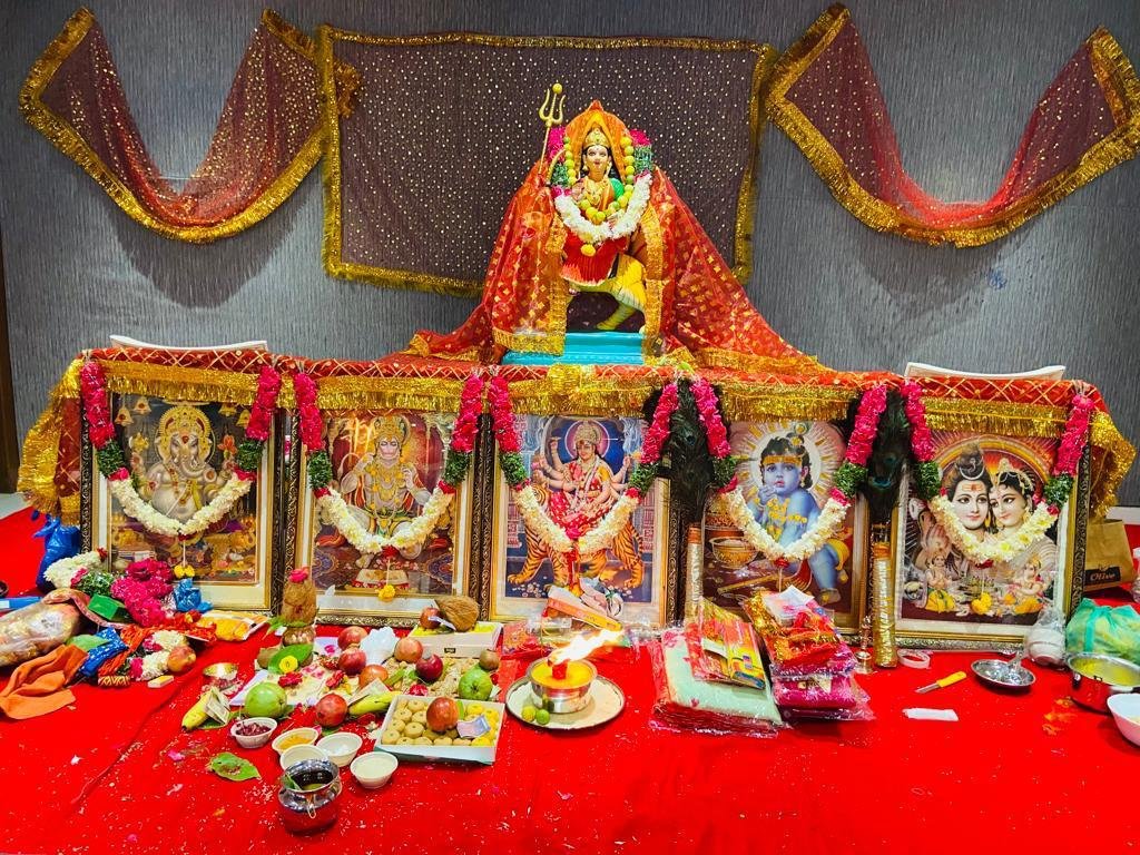 Religious puja setup with deities and offerings